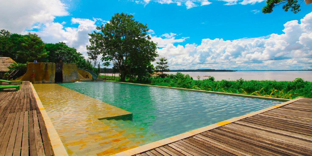 Piscina del hotel con deck de madera y el río Amazonas al fondo